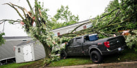 A truck sits with a tree toppled on it in the Frenchtown Villas Monroe in Newport on Friday, Aug. 25, 2023 after a heavy band of storms hit the region on Thursday, Aug. 24, 2023.