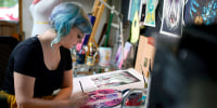 Artist Kelly McKernan paints in their studio in Nashville, Tenn.