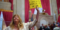 Rep. Gloria Johnson, D-Knoxville, holds a sign on the House floor after a special session of the state legislature on public safety adjourned on Aug. 29, 2023, in Nashville.