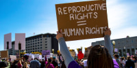 A protester holds a placard up that says "Reproductive rights = Human rights". Protestors gathered to voice their anger at the leaked Supreme Court documents.