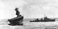 USS Yorktown lists heavily to port after being struck by bombs and torpedoes during the Battle of Midway in June 1942.