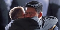Lt. Dan Choi, a gay Army officer honorably discharged under "don't ask, don't tell," receives a hug before President Barack Obama signs the act lifting the ban on homosexuals serving openly in the U.S. armed forces at the Department of the Interior on Dec. 22, 2010.