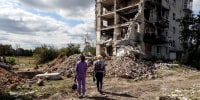 Two women look at an apartment block in Izium, Ukraine, ruined in the shelling of Russian troops on the first anniversary of the liberation of the city from Russian invaders, on Sept. 20, 2023.