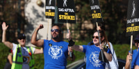 WGA members carry SAG-AFTRA signs in support as striking SAG-AFTRA members picket outside Warner Bros. Studio as the actors strike continues on September 26, 2023 in Burbank, California. Hollywood is awaiting the final vote on a tentative contract agreement between over 11,000 Writers Guild of America (WGA) members and Hollywood studios in the nearly 150-day writers strike.