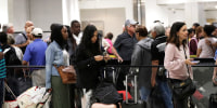 Passengers wait in line at a security checkpoint at Miami International Airport in Miami amid the government shutdown, on Jan. 18, 2019. 