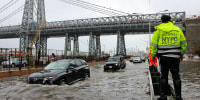 Motorists drive through floodwaters on FDR Drive in Manhattan near the Williamsburg Bridge on Friday, Sept. 29, 2023.