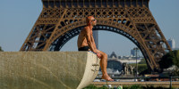 A man sunbathes at the Trocadero fountains in front of the Eiffel Tower on Sept. 7, 2023, in Paris. 
