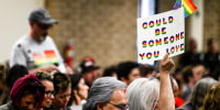 Parents, students, and staff of Chino Valley Unified School District hold up flags and signs in favor of protecting LGBTQ+ policies at the school board meeting 