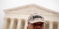 A person wears an NRA hat in front of the Supreme Court in 2022. 