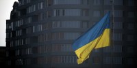A Ukrainian flag flies in the square in front of the city hall