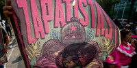 A supporter of the Zapatista Army of National Liberation, EZLN, holds up a poster in Mexico City.