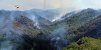 An Army helicopter douses a wildfire burning east of Mililani, Oahu, Hawaii, on Thursday, Nov. 2, 2023. 