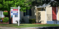A For Sale sign is posted in front of a home for sale in San Marino, Calif.