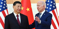 Chinese President Xi Jinping and President Joe Biden pose for press photos at the G20 summit in front of the Chinese flags and American flags