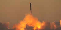 a rocket ascends into the sky amidst smoke from the launch