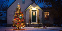 Outdoor Christmas tree decorated with lights in front of home. 
