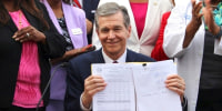 Roy Cooper signs a Medicaid expansion law at the Executive Mansion in Raleigh, N.C., on March 27, 2023. 