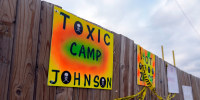 Signs protesting the construction of a government-run tent encampment for migrants are mounted in Chicago, on Dec. 4, 2023. 