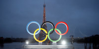 People walk in the rain The unveiling of the Olympic rings in Paris.