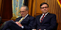Senate Majority Leader Chuck Schumer (D-NY) and Speaker of the House Mike Johnson (R-LA) listen to remarks at the Capitol Building on Dec. 12, 2023.