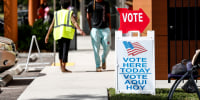 Voters wait in line cast their ballots at a polling precinct during early voting