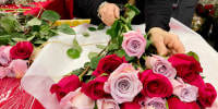A woman arranges flowers on Valentines Day at Whole Foods Market in Annapolis, Md., on Feb. 14, 2023.