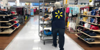 A Walmart employee pushes a cart through a Walmart store in Richmond, Calif. Beat Expectations