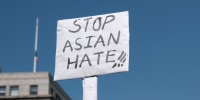 A protester holds a sign that reads  "Stop Asian Hate."
