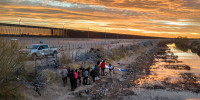  a Texas National Guardsman blocks immigrants from passing through razor wire after they crossed the Rio Grande into El Paso, Texas on Feb. 1, 2024 from Ciudad Juarez, Mexico.