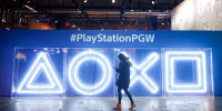 A woman walks past the Sony PlayStation Buttons Logo during 'Paris Games Week' in Paris