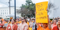 Carrie McNair holds a sign for IVF rights