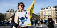 Image: A woman holds a poster of human rights group of 'Amnesty International' bearing the word "Victory" on a uterus drawing