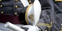 A cadet holds his diploma and cap during the graduation ceremony