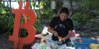 A woman sells fruit in a market during a Bitcoin summit, in Chiltiupan, El Salvador
