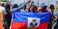 People carry a Haitian flag during a demonstration