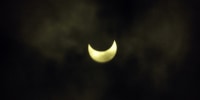 The solar cclipse is seen through cloudy weather