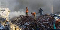 Emergency personnel extinguish a fire at the site of strikes which hit a building next to the Iranian embassy in Syria's capital Damascus, on April 1, 2024.