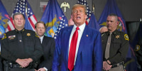 Former President Donald Trump is surrounded by law enforcement officers at a campaign event in Grand Rapids, Mich., Tuesday, April 2, 2024.