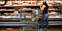 A customer looks at meat inside a Walmart.