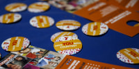 Census 2020 pins and leaflets are displayed on a table during a community food distribution at a YMCA location in Los Angeles