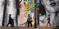 A triptych with various people walking in front of murals in Richmond, Virginia