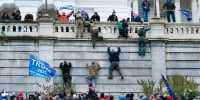 Rioters climb the west wall of the the Capitol