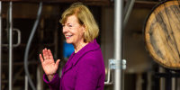 Tammy Baldwin waves as she walks off stage after speaking