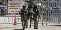 Haitian police officers walk out of the international airport in Port-au-Prince, Haiti