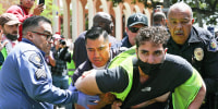 USC public safety officers detain a demonstrator during clashes after officers attempted to take down an encampment in support of Gaza at the University of Southern California on April 24, 2024 in Los Angeles,.