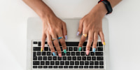 Close-up of woman hands using laptop on table at home