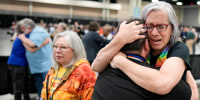 Angie Cox, left, and Joelle Henneman hug after an approval vote at the United Methodist Church General Conference