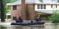 Emergency workers with Caney Creek Fire and Rescue boat out dogs from a flood portion of River Plantation Drive in River Plantation, Texas