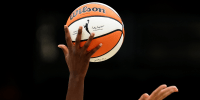 A detail of the WNBA logo is seen on the basketball during an opening tipoff 