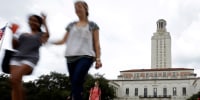 students walk through the University of Texas at Austin campus near the school's iconic tower